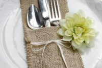 a burlap pocket for utensils decorated with a white bloom is a lovely idea for a rustic wedding