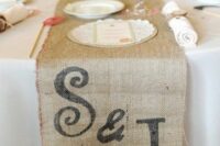 a burlap table runner with monograms is a chic rustic wedding solution to go for