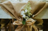a burlap table runner with rope and some white blooms and greenery will beautifully accent your wedding tablescape