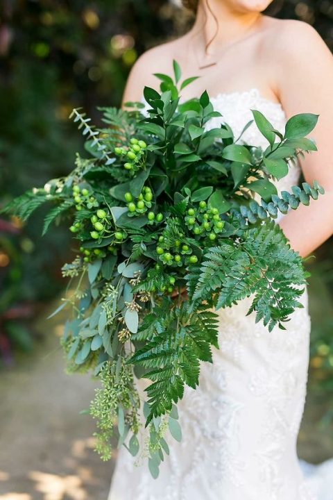 a cascading wedding bouquet with leather leaf fern, seeded eucalyptus, baby blue eucalyptus, foliage and hypericum berries