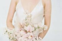 a catchy wedding bouquet of blush orchids and some light pink blooms plus grasses is a delicate idea for a spring bride
