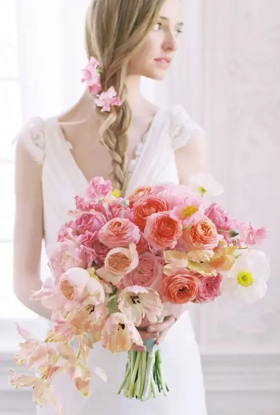 a chic ombre wedding bouquet of peachy, pink, and bright pink blooms is a stylish and bold idea to rock