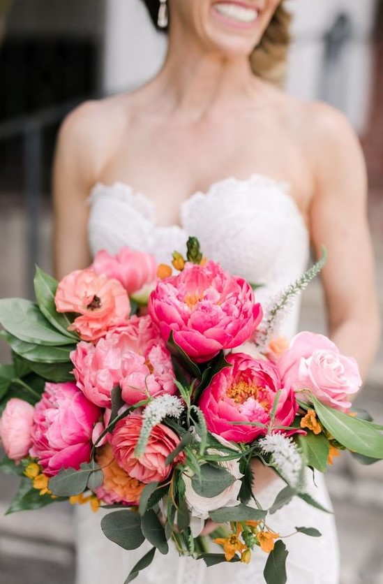 a colorful wedding bouquet of light pink and coral peonies, yellow blooms and greenery is cool for summer