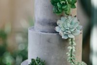 a concrete wedding cake decorated with succulents is a lovely idea for a modern or minimalist wedding, it looks edgy and bold