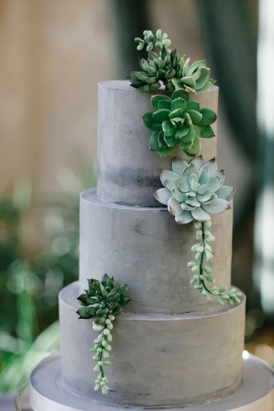a concrete wedding cake decorated with succulents is a lovely idea for a modern or minimalist wedding, it looks edgy and bold