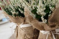 a country wedding centerpiece of astilbe wrapped in burlap, with ribbon bows is amazing for a rustic wedding