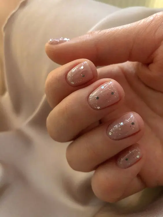 a delicate and beautiful wedding manicure with gold polka dots and small splatters is chic for spring or summer