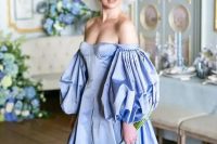 a fantastic royalty-inspired off the shoulder blue wedding dress with a corset, puff sleeves and a pleated skirt plus a veil bow