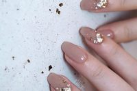 a grey wedding manicure highlighted with large gold rhinestones for a refined bride