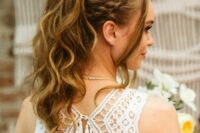 a high wavy ponytail with a braided halo, a bump on top and face-framing locks is a gorgeous boho wedding hairstyle