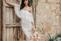 a jaw-dropping off the shoulder boho lace sheath wedding dress, statement earrings and nude shoes for a boho bridal look