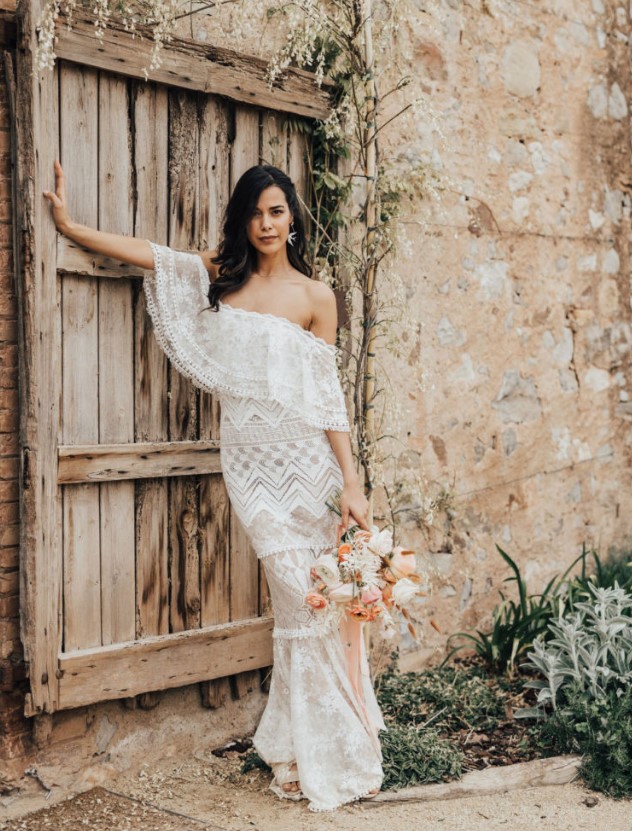 a jaw dropping off the shoulder boho lace sheath wedding dress, statement earrings and nude shoes for a boho bridal look