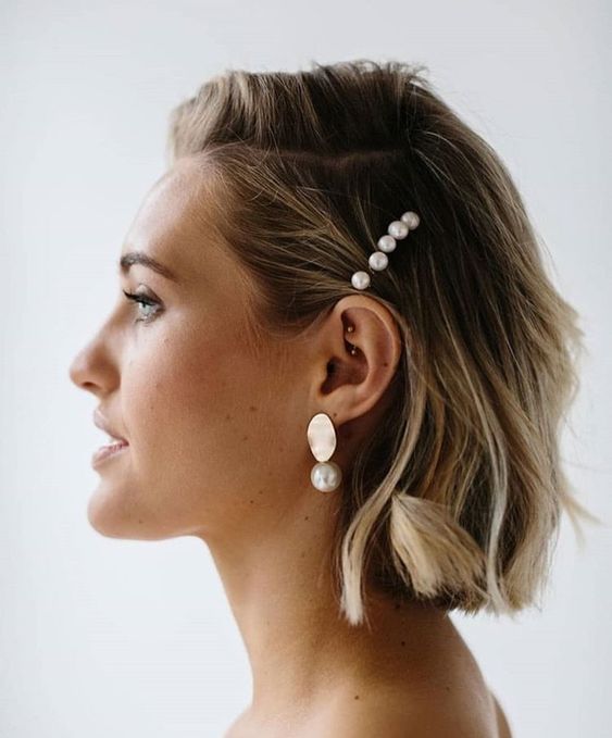 a laconic wavy bob with side parting and a pearl hairpiece plus matching earrings is all about modern chic