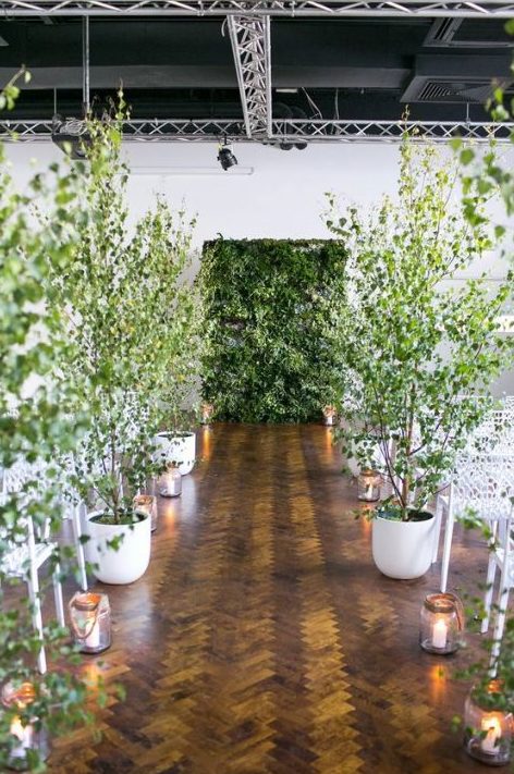 a living greenery wall and potted trees turn the indoor ceremony space into a real forest, this is a great solution for an indoor spring wedding