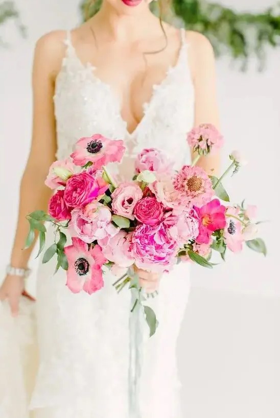 a lovely blush and hot pink wedding bouquet with greenery and long green ribbon hanging down is ideal for a Valentine wedding
