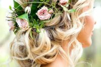 a low wavy updo with some waves down, a volume on top, some greenery and pink blooms is great for both summer and spring