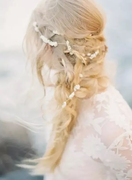 A messy layered braid with twists and a pearl hair vine for a coastal or beach bride with a laid back touch