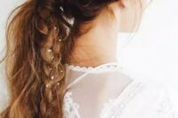 a messy textural ponytail with a bump and a side braid with tin flowers in for a boho bride