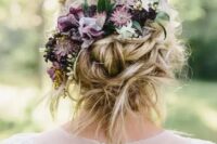 a messy twisted low updo with some hair down and moody fresh blooms plus a bump