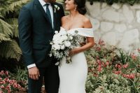 a modern and chic off the shoulder plain mermaid wedding dress with a trian and a slight V neckline for a modern wedding