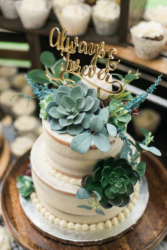 a naked wedding cake decorated with sugar beads, with succulents, greenery and blooms, with a gold calligraphy topper is amazing