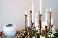 a navy ombre wedding cake topped with blueberries, a navy velvet table runner and lots of white candles