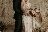 a peachy pink and neutral off the shoulder wedding dress with floral appliques, puff sleeves and a train