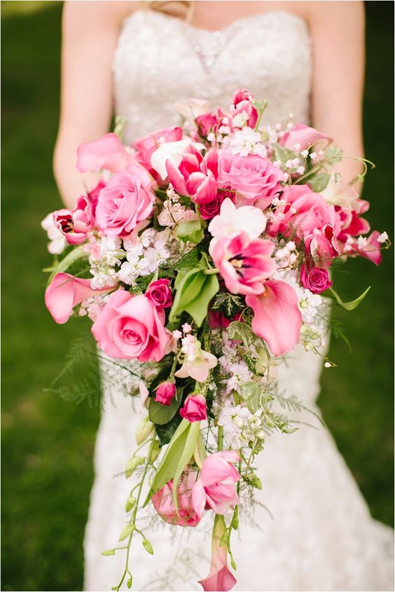 a pink cascading wedding bouquet with roses, lilies and some white fillers plus greenery is a cool and chic idea to make a statement