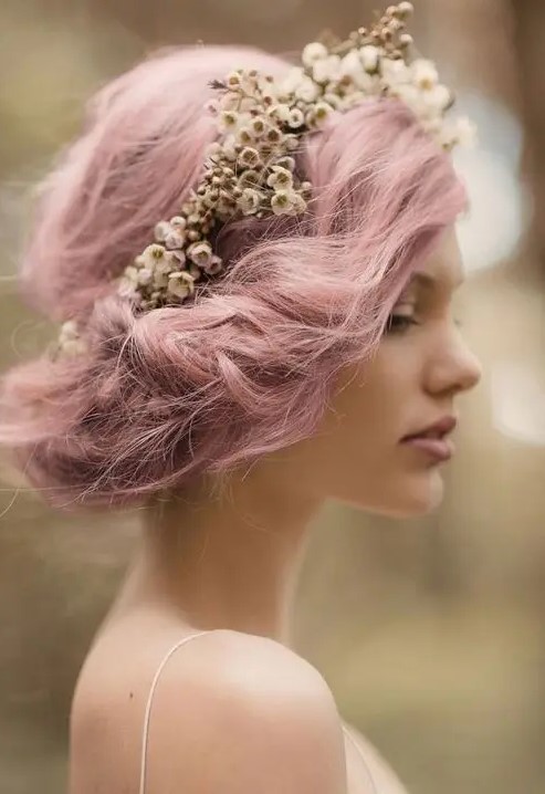 a pink twisted wedding side updo with a bump and a floral crown for an airy and romantic spring bridal look