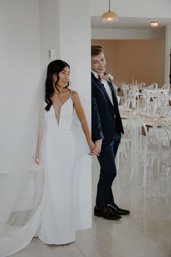 a plain mermaid wedding dress with an illusion plunging neckline, spaghetti straps and a train is a chic and beautiful idea