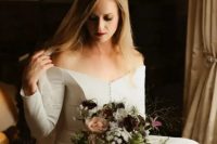 a plain off the shoulder wedding dress with long sleeves and a button row plus a lace veil for a modern fairy tale wedding