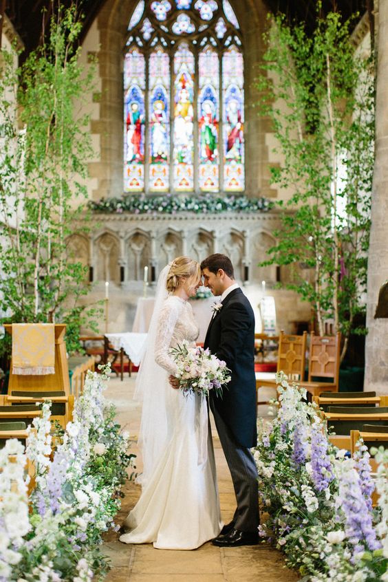 a refined spring wedding aisle done with long-stem white and purple blooms, with potted trees for a real fresh feel and a forest impression