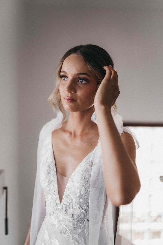 a romantic lace applique wedding dress with an illusion plunging neckline, bows and ribbons is a stylish and catchy idea for a wedding