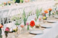 a rustic backyard wedding tablescape with neutral linens, a burlap runner, bright cluster floral centerpieces and printed plates is a cool idea