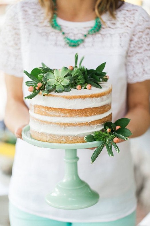 a simple naked cake topped with succulents, berries and greenery for a modern rustic wedding