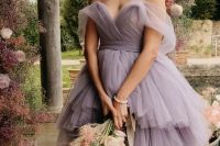 a sophisticated lavender off the shoulder wedding dress with a layered maxi skirt and a sculptural bodice for a garden bride