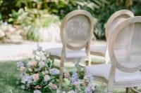 a sophisticated spring garden wedding aisle with blush and lilac blooms, berries and greenery plus chic vintage chairs