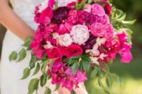 a super bright and lovely wedding bouquet of hot pink, purple and fuchsia blooms, with lots of greenery and pink ribbon is amazing
