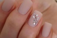 a super subtle and chic spring wedding manicure with matte blush nails and a silver foil branch that adds interest to them