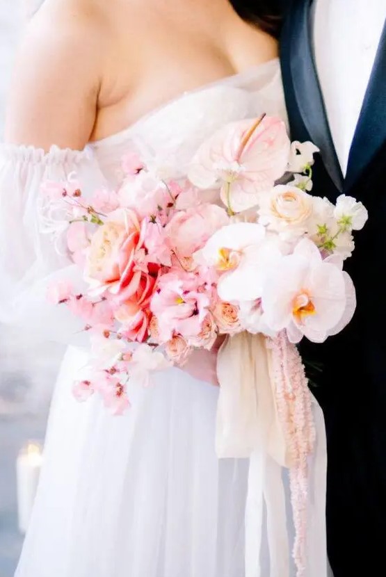 a tender ombre wedding bouquet of blush, light pink and white blooms and pink and white ribbons