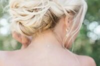 a twisted low bun with some locks down, with locks framing the face is a gorgeous idea for a chic and elegant look not only at a beach wedding