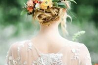 a twisted updo with a texture and some bright blooms and greenery looks fabulous