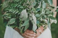 a very lush wedding bouquet of evergreens and eucalyptus for a casual bride