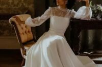 a vintage-inspired A-line plain and lace wedding dress with a turtleneck, puff sleeves, a train, statement earrings and a bold lip