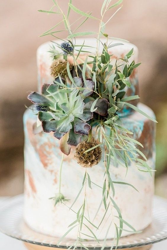 a watercolor succulent wedding cake decorated with succulents, seed pods, thistles, herbs and greenery looks unusual and very creative