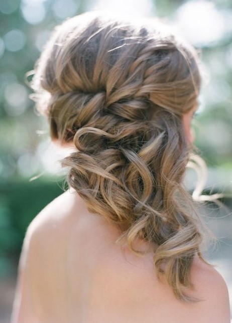 a wavy and braided half updo with a bump is a stylish and chic idea for a wedding