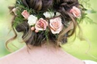 a wavy low updo with a twisted top and some waves down, with greenery, pink and white roses feels very summer-like
