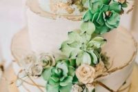 a white wedding cake with gold leaf and gold stripes, with sugar succulents, blooms and twigs is a lovely idea for many weddings with a glam touch