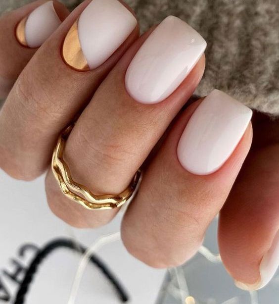 a white wedidng manicure with two nails done with gold foil is an ultra-modern and bold solution suitable not only for spring