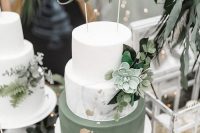 a white, white marble and green wedding cake with gold leaf, with greenery and succulents, with a gold calligraphy topper is amazing